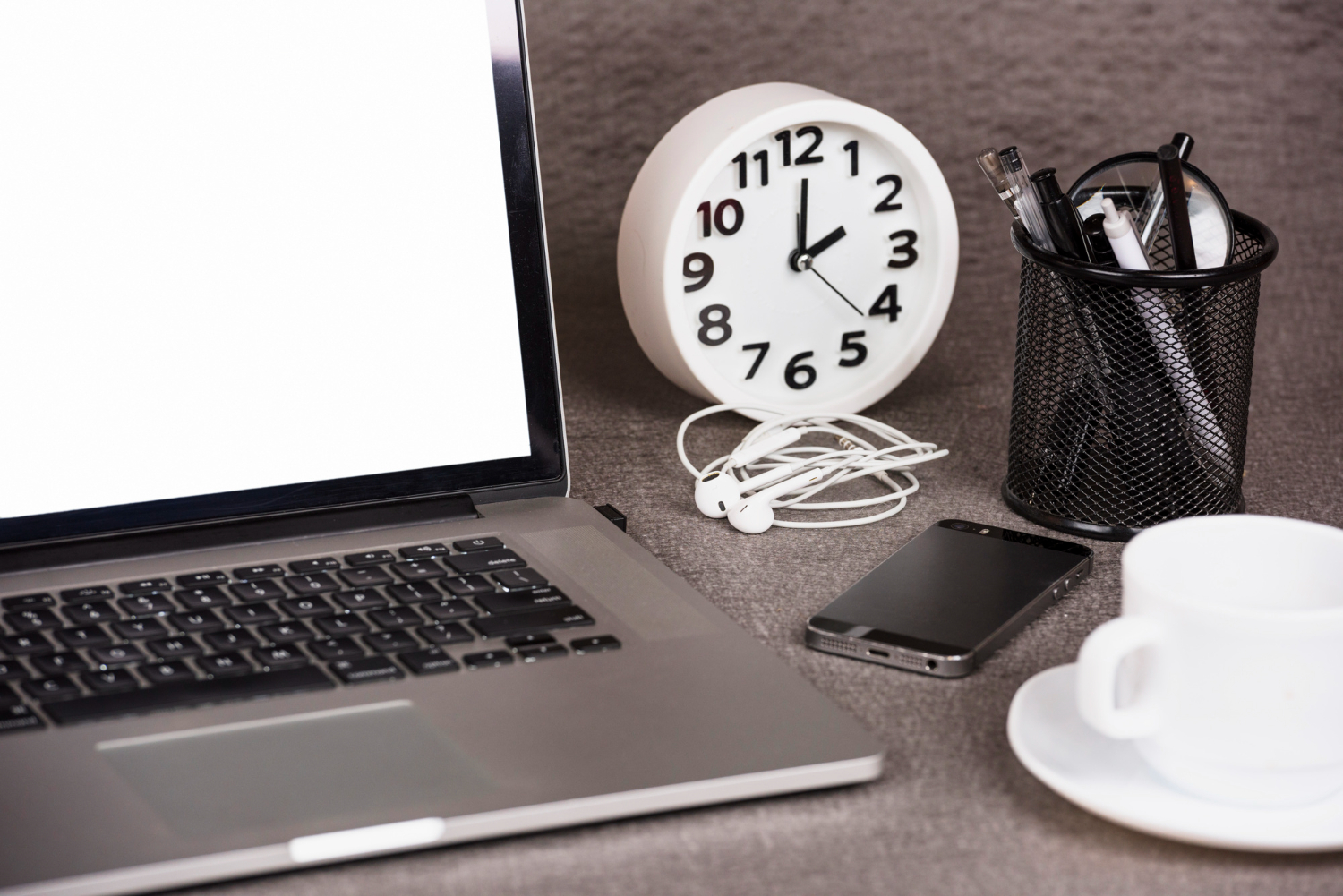 Laptop mit Uhr auf einem Schreibtisch