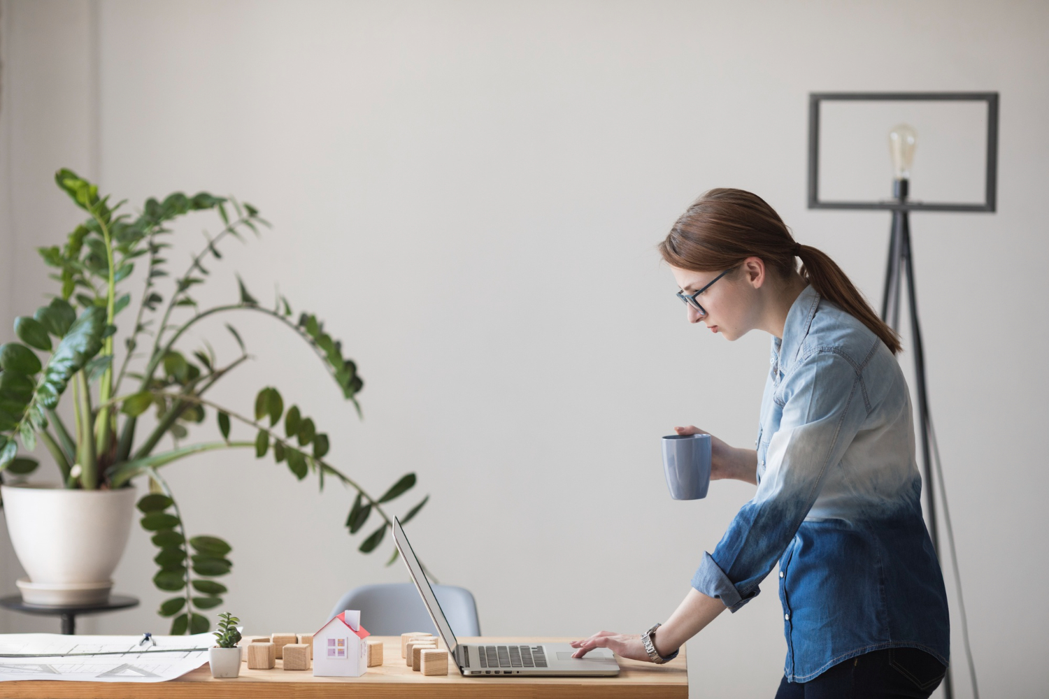 Frau stehend am einem Schreibtisch im Homeoffice