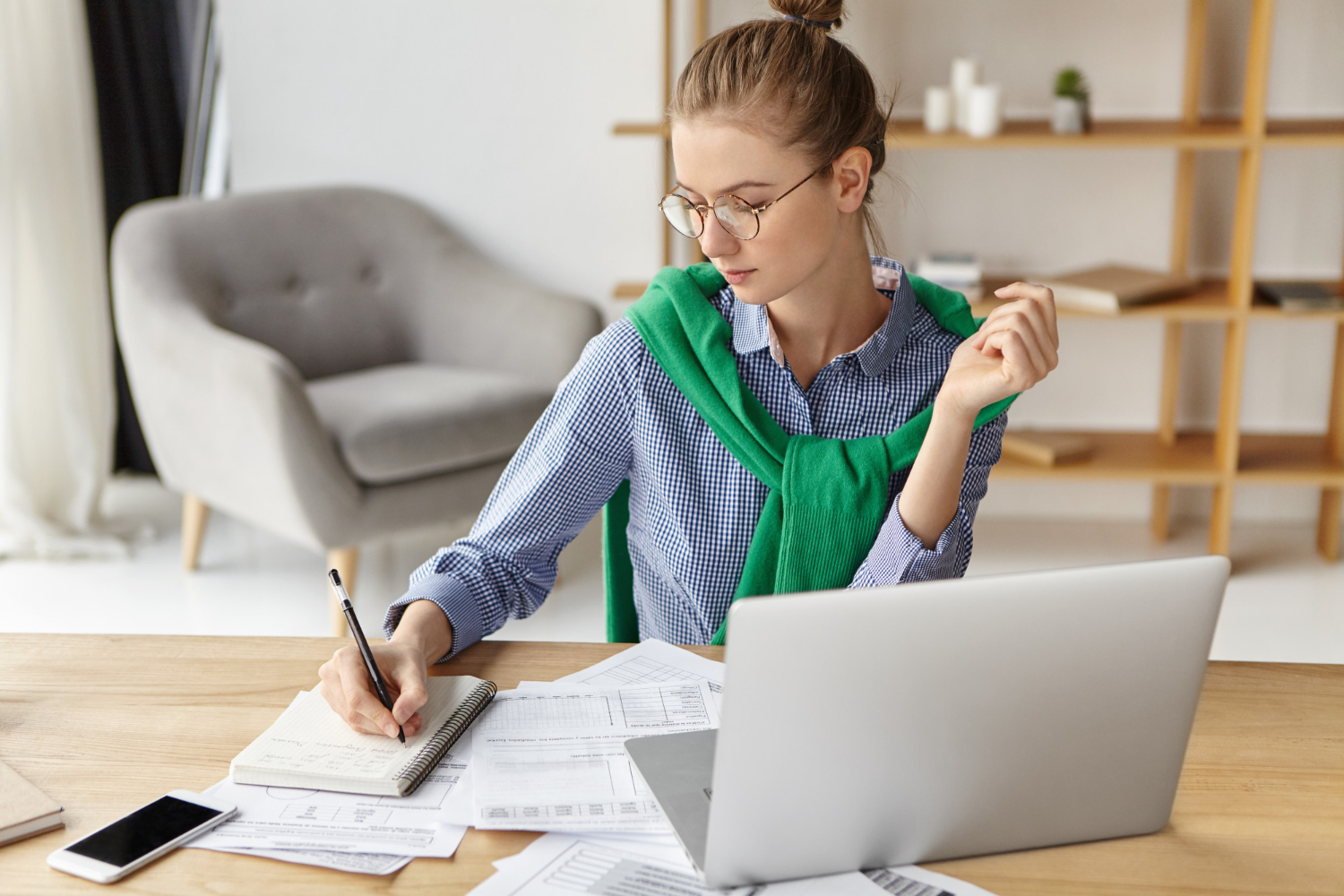 Homeoffice Frau am schreibtisch sitzend und Listen am schreiben